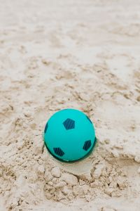 Kaboompics - Pale Beach Sand Texture with a Turquoise Toy Ball for Summer Design
