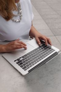 Kaboompics - Close-Up of Hands Typing on a Laptop at a Cafe