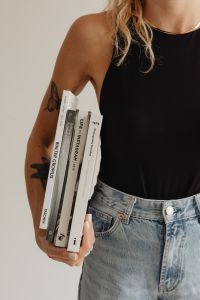 Kaboompics - Woman Carrying a Stack of Books in Light Blue Jeans