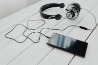 Kaboompics - Black Smartphone and Wired Headphones on White Wood
