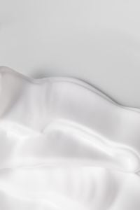 Kaboompics - Smooth White Skincare Cream Ridge on a Pale Gray Surface with Generous Copy Space, Minimal Beauty Product Background