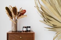Kaboompics - Dried Botanicals and Candle Jars Styled on a Walnut Console with Palm Leaf Backgrounds