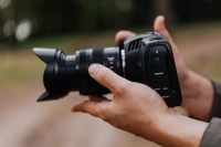 Kaboompics - Person Holding Black Cinema Camera with Zoom Lens Outdoors