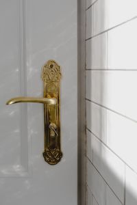 Kaboompics - Gold Door Handle with Keyhole and White Subway Tile in Sunlight
