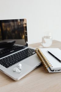 Kaboompics - Laptop with AirPods, Notebook, Pen and Glass of Water