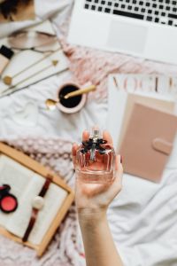 Kaboompics - Hand Holding Perfume in a Cozy Laptop Workspace with Coffee