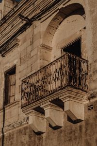 Kaboompics - Historic Stone Balcony with Arched Doorway and Wrought Iron Railing