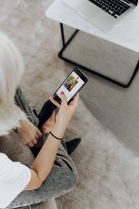 Kaboompics - Overhead Close-Up of Woman Browsing Her Phone Beside Laptop