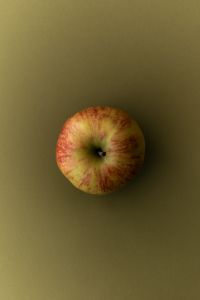 Kaboompics - Whole Apple on Olive Green Background