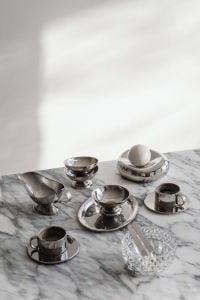 Kaboompics - Assorted Chrome Coffee Cups, Silver Bowls and Spoons on Marble, Metallic Tableware Still Life