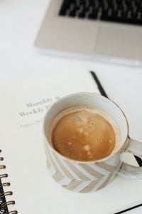 Kaboompics - Overhead Coffee Cup and Weekly Planner in a Minimal Work Setup