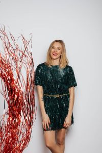 Kaboompics - Laughing Woman in Green Dress With Red Tinsel