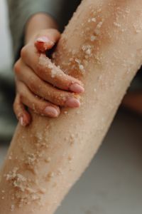 Kaboompics - Hands Rubbing Coarse Salt Exfoliant into the Skin on a Calf