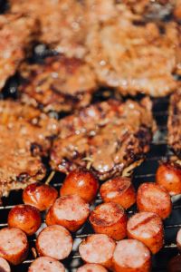 Kaboompics - Close-Up of Juicy Grilled Pork Neck and Sausage on a Charcoal Grill, Barbecue Food Photography