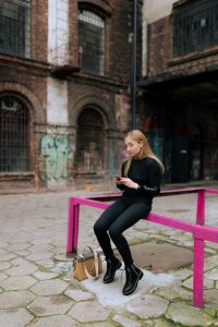 Kaboompics - Urban Lifestyle Portrait of a Woman Checking Her Smartphone on a Fuchsia Rail