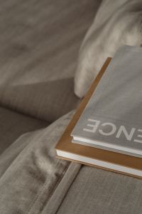 Kaboompics - Neutral Books and a Closed Planner on a Textured Sofa, Home Office Detail