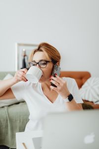 Kaboompics - Woman Talking on Her Mobile Phone During a Cozy Home Office Coffee Break