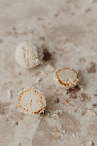 Kaboompics - Coconut Truffle Cross-Sections with Creamy Centers on Pale Marble, Close-Up Dessert Texture