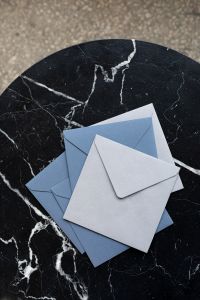 Kaboompics - Blue and White Envelopes on Black Marble, Vertical Flat Lay with Copy Space