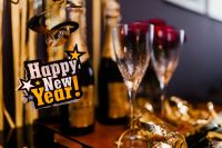 Kaboompics - Happy New Year Bottle Tag with Champagne Glasses and Gold Party Streamers