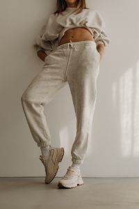 Kaboompics - Woman in Neutral Joggers Stretching in a Minimalist Interior