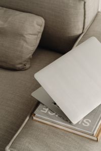 Kaboompics - Top-Down View of a Laptop and Books on a Textured Neutral Sofa