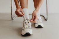 Kaboompics - Side View of Woman Tying Sneakers With White Crew Socks