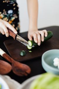 Kaboompics - Whole Cucumber Being Sliced for Salad on a Dark Cutting Board