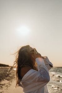 Kaboompics - Blonde Woman in White Shirt Facing Sunset by the Sea