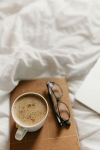 Kaboompics - Coffee Cup, Glasses and Notebook on White Bedding, Cozy Morning Still Life