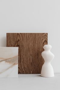 Kaboompics - Sculptural White Ceramic Vase with Dark Wood and Marble Samples, Minimalist Product Background