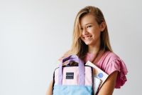Smiling Schoolgirl Holding Colorful Backpack
