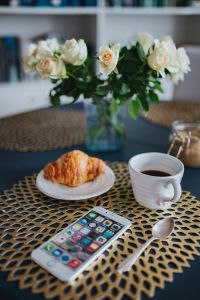 Round breakfast table with white flowers and golden coffee mats