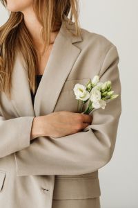 Kaboompics - Woman in Beige Suit Holding a Small Bouquet of White Flowers