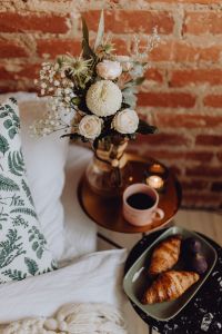 Kaboompics - Croissants and figs on a green plate, a cup of coffee and a candle