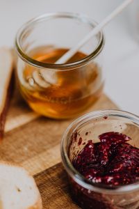 Kaboompics - Honey and Raspberry Jam Jars With Toast and Flowers