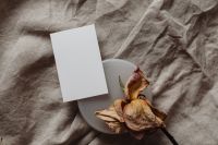 Kaboompics - Overhead Portrait Card beside a Dried Rose on Neutral Linen