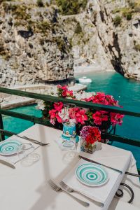 Kaboompics - Seaside Dining Table with Petunias and Rocky Amalfi Coast View