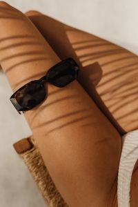 Kaboompics - Close-Up of Black Sunglasses on Sunlit Skin, Summer Accessory