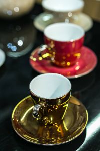 Kaboompics - Vertical Red and Gold Teacup Arrangement with Shallow Focus on Glossy Table