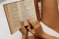 Kaboompics - Summer Reading on White Pebble Beach with Straw Hat and Open Book