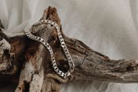 Kaboompics - Layered Silver Chain Necklaces on Driftwood with Light Copy Space