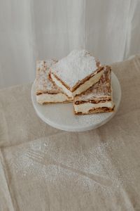Kaboompics - Powdered Napoleonka Squares with Crumbs on a Linen Table