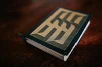 Kaboompics - Illustrated Hardcover Book on a Dark Wooden Table