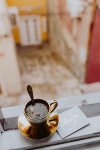 Kaboompics - Drink coffee in a golden cup at the window