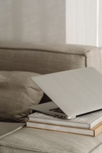 Kaboompics - Closed Laptop on Books on a Sofa, Neutral Home Office Detail