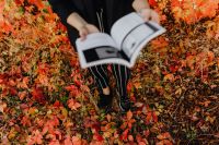 Kaboompics - Wide Autumn Reading Lifestyle Photo of a Woman in Black Holding an Open Graphic Design Book