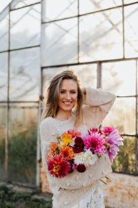 Kaboompics - Smiling Woman Holding Dahlia Bouquet In Greenhouse
