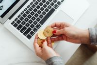 Kaboompics - Hands Holding Bitcoin Coins Beside Laptop