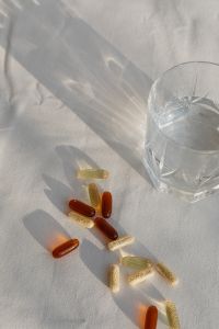 Kaboompics - Assorted Vitamins Beside a Glass of Water